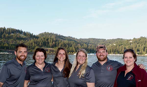 Six people in group in front of lake