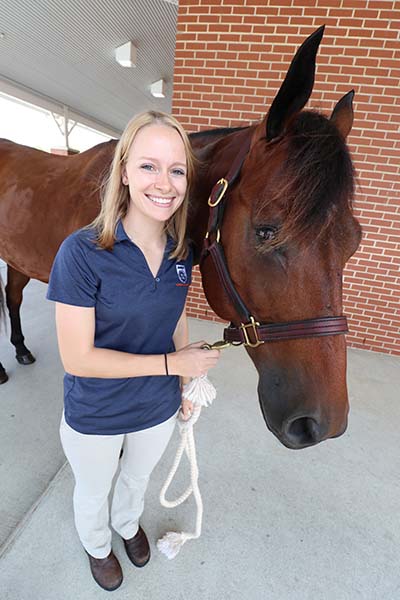 Rachel Pfeifle holds a horse